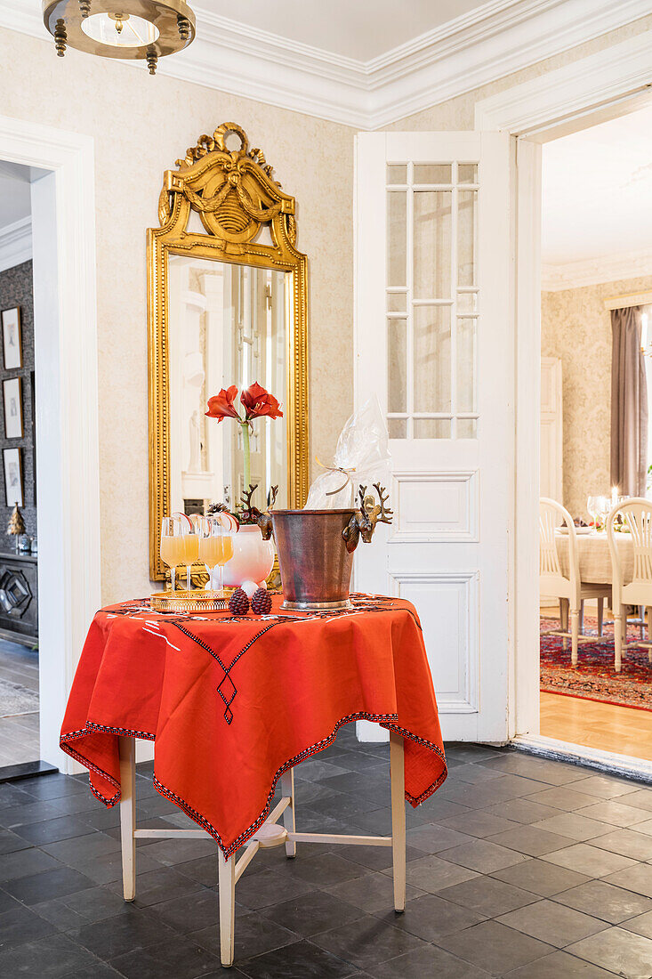 Welcome drinks on a round table with a red tablecloth in the entrance hall