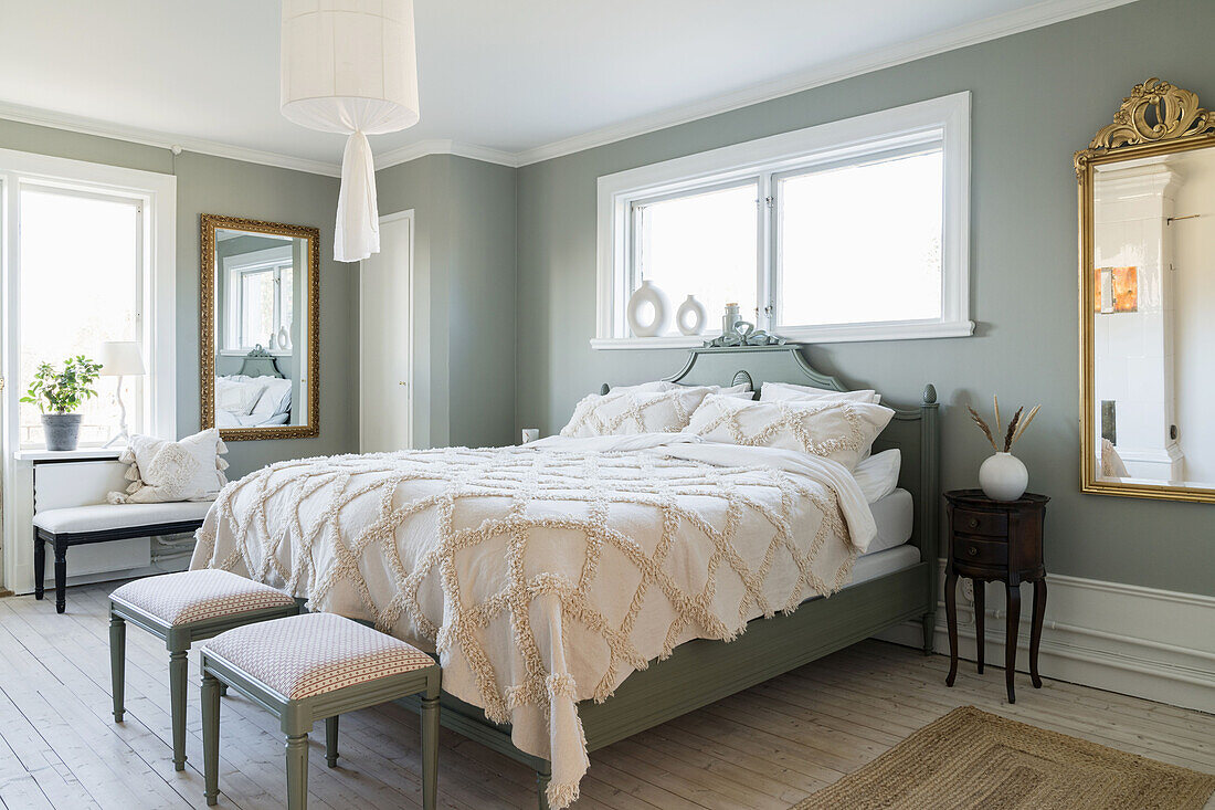 Queen size bed in light bedroom with grey-green walls