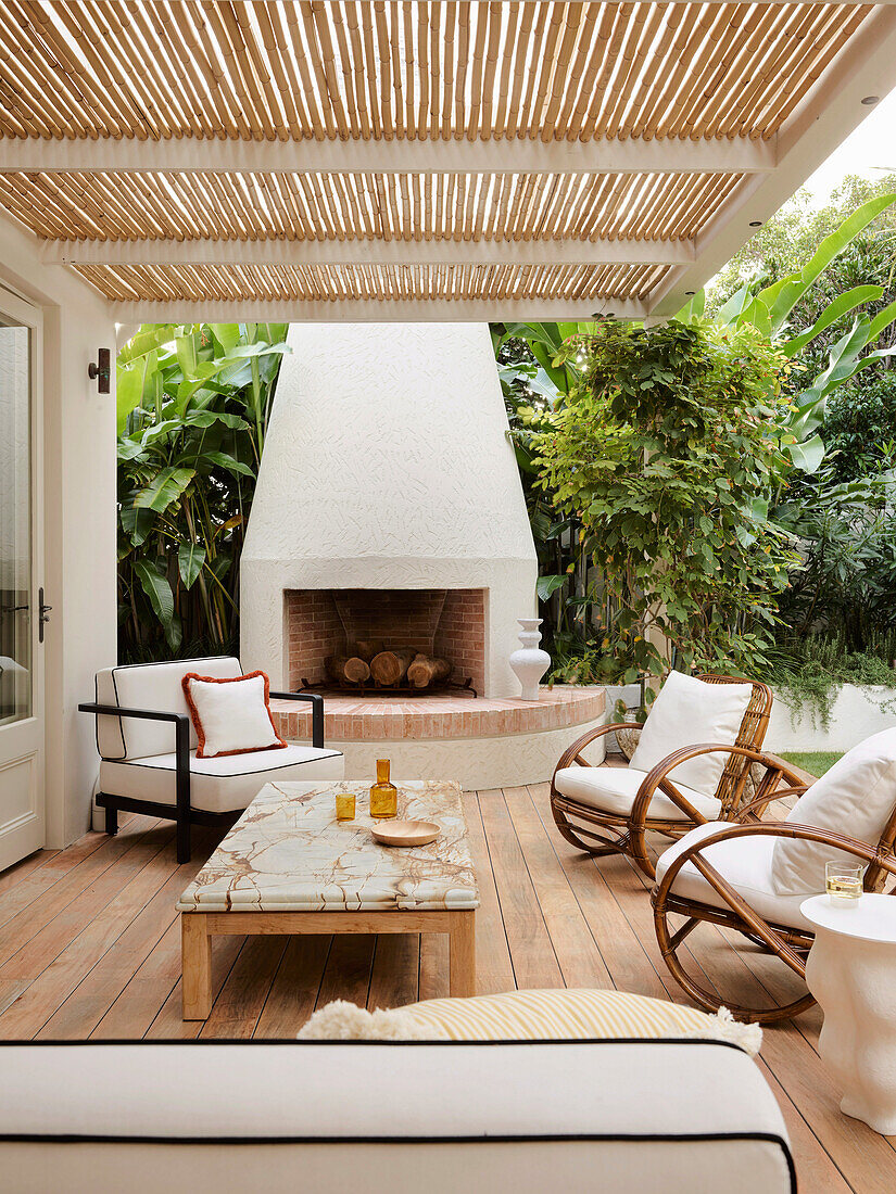 Covered terrace with fireplace, outdoor furniture and marble-topped coffee table