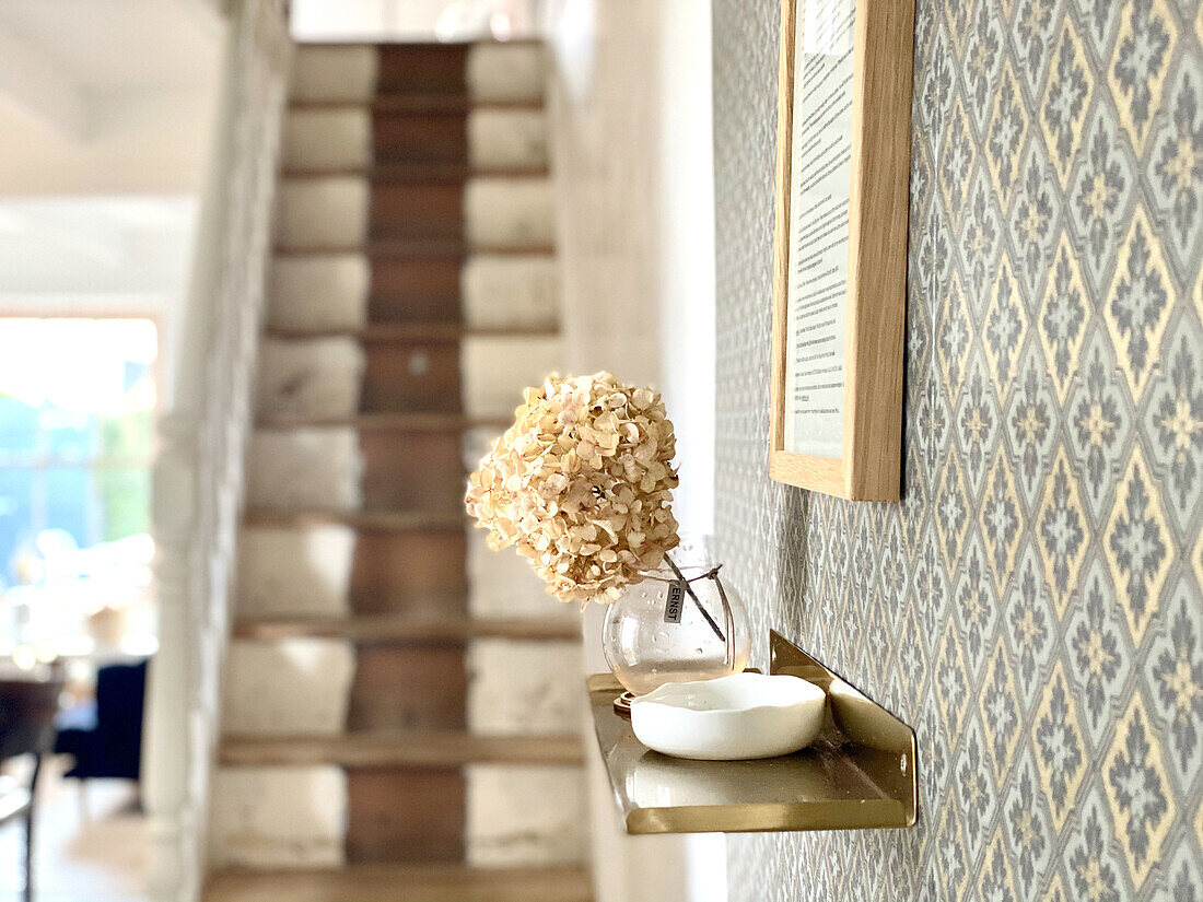 Floating shelf bowl and hydrangea flower on wall with wallpaper