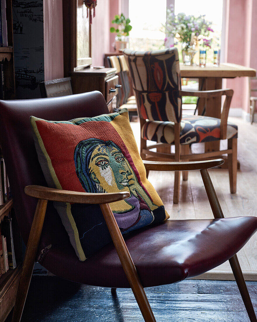 Graphic throw pillow on a leather chair from the middle of the century