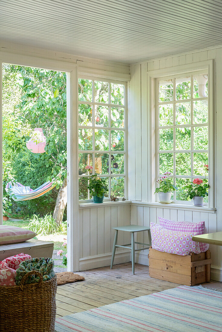 Sommerlicher Wintergarten mit Sprossenfenstern im Schwedenstil