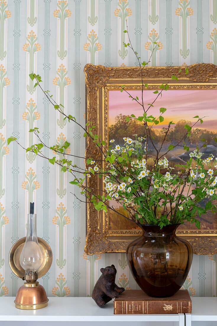 Glass vase with bouquet of flowers, painting and vintage-style wallpaper