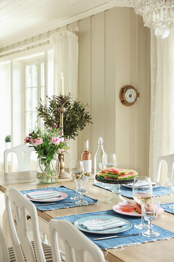 Sommerlich gedeckter Tisch mit blauen Tischsets im Esszimmer