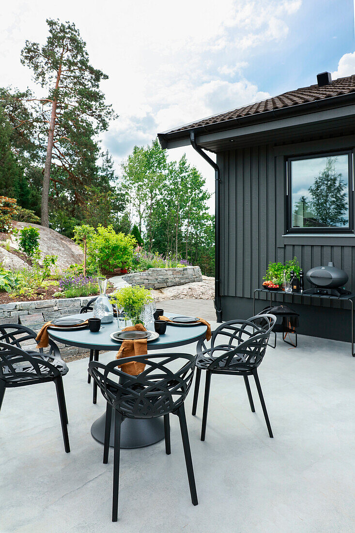 Moderner Outdoor-Essplatz in Grau auf der Terrasse am Felsen