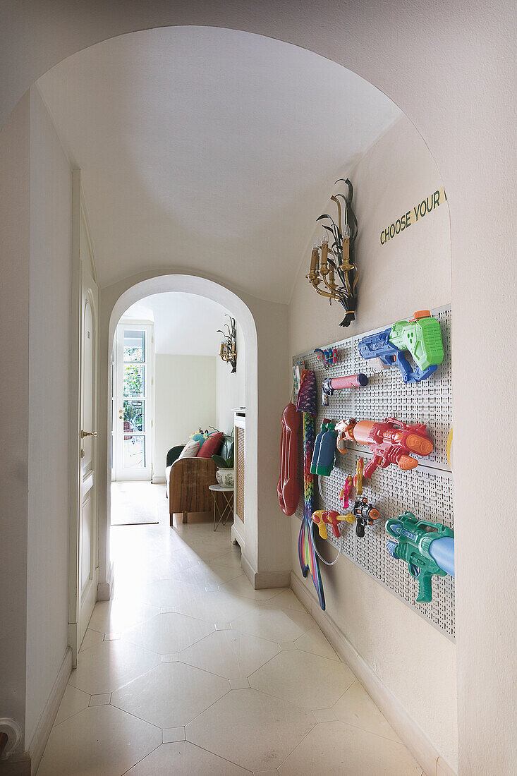 Colourful water pistols hung on hallway wall