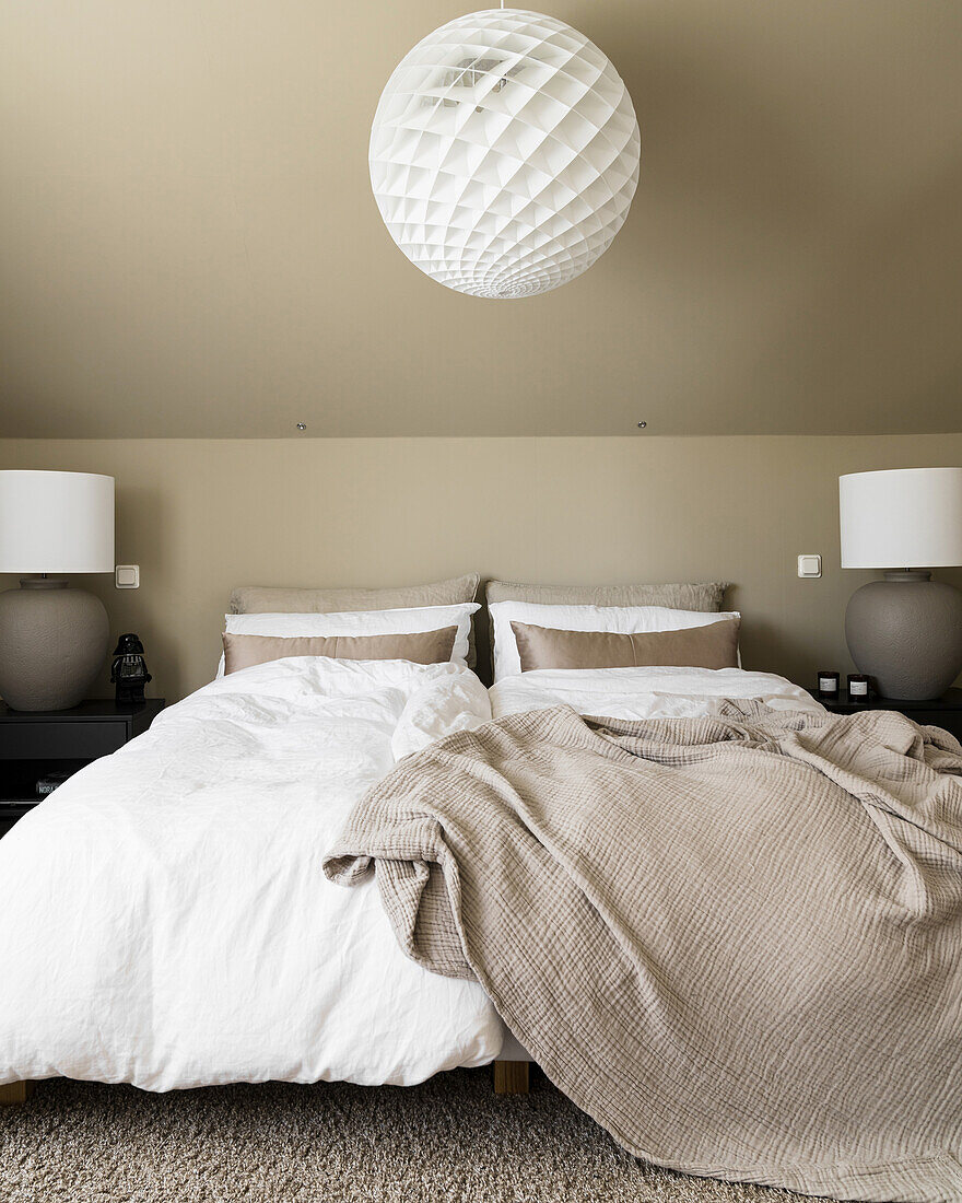 Double bed in bedroom in beige tones