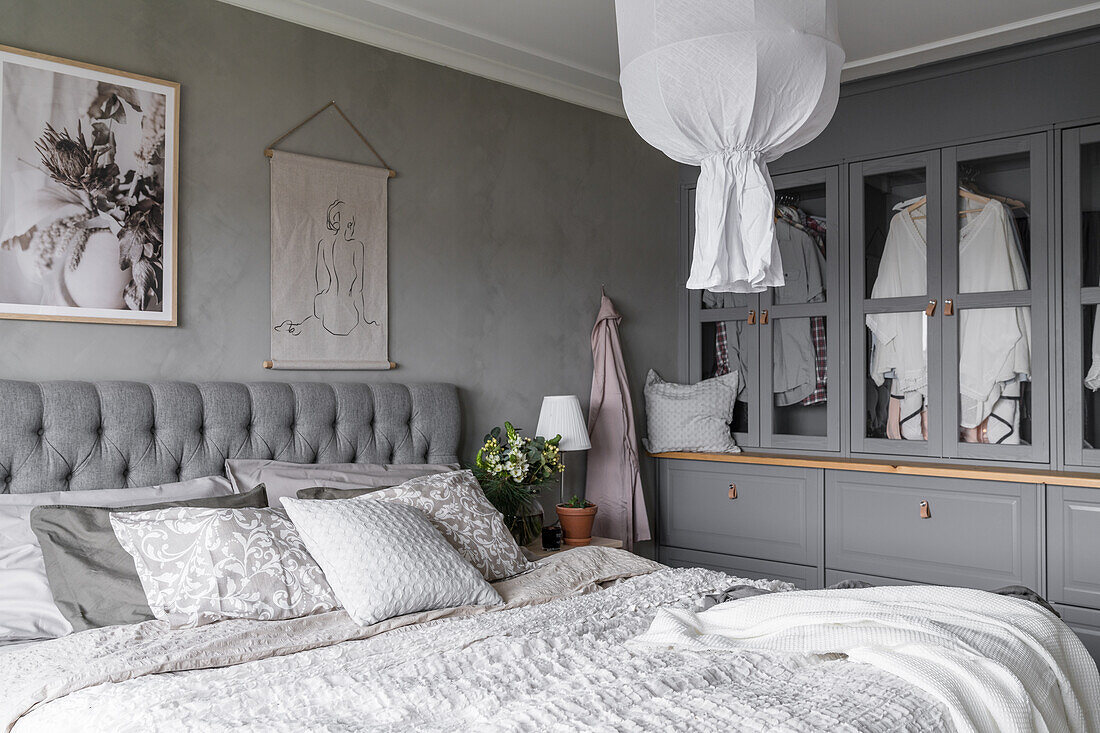 Schlafzimmer in Grautönen mit Doppelbett und selbstgebautem Kleiderschrank