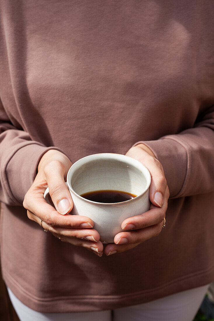 Frauenhände halten Becher mit Kaffee