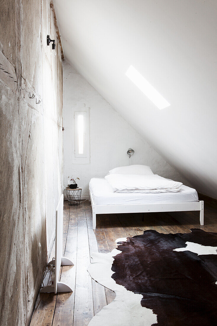 Doppelbett und rustikaler Einbauschrank im Zimmer mit Dachschräge