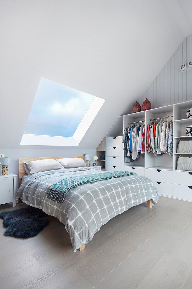 Doppelbett und Garderobenschrank im Schlafzimmer mit Dachschräge