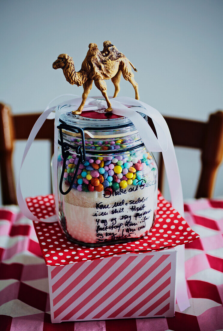 DIY-Glas mit bunten Perlen und Kamelfigur auf gepunkteter Unterlage