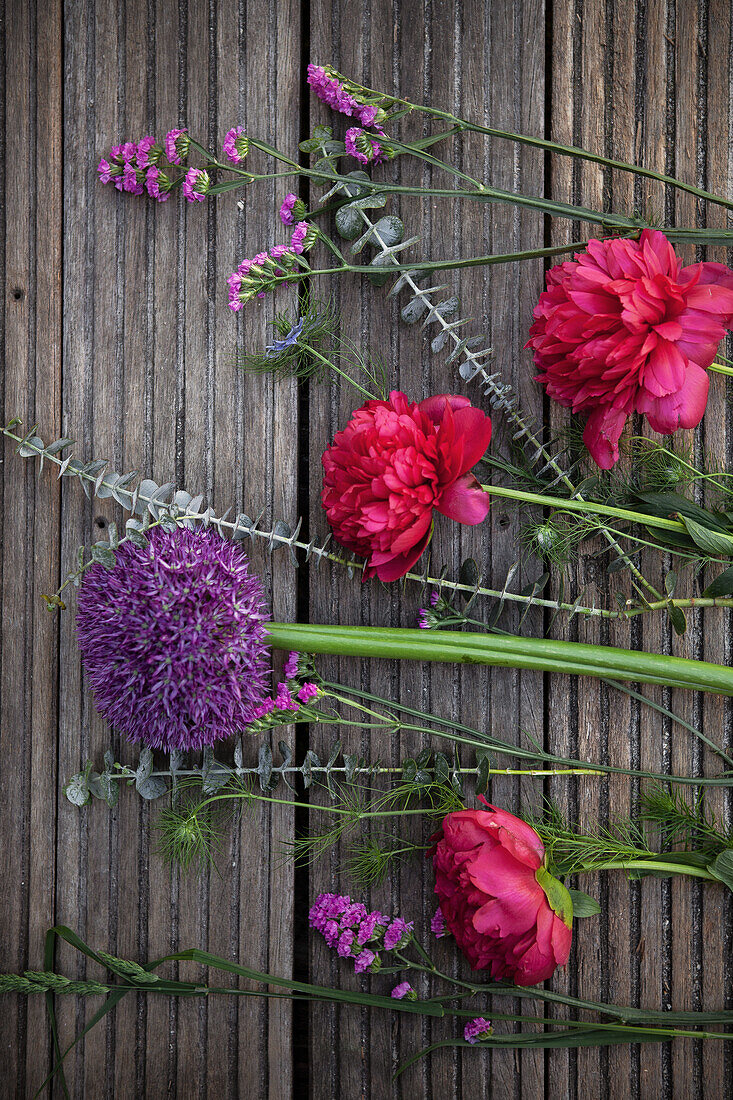 Tableau of ingredients for an early summer bouquet of peonies, alliums, sea lavender, love-in-a-mist and eucalyptus