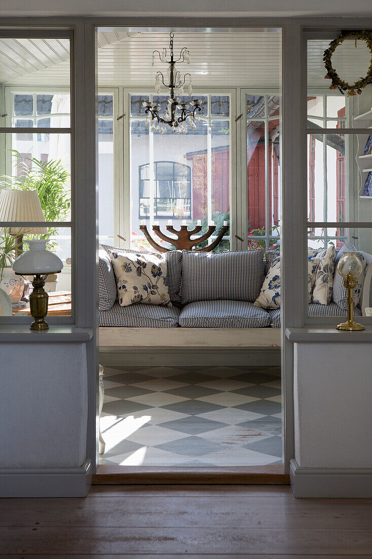 View of sofa in the conservatory with grey and white checkered wooden floor