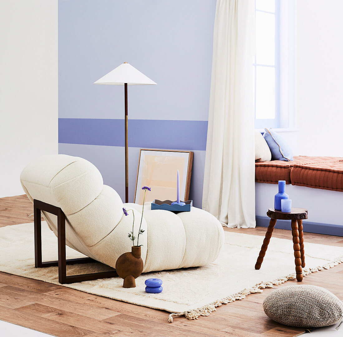 Gemütlicher Designersessel auf in Naturweiß im Zimmer mit lila Wand