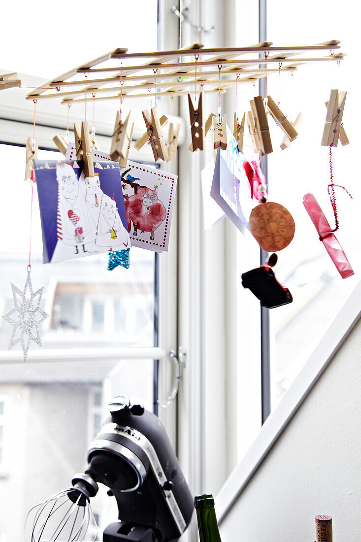 DIY mobile with photos, cards and decorative elements by the window