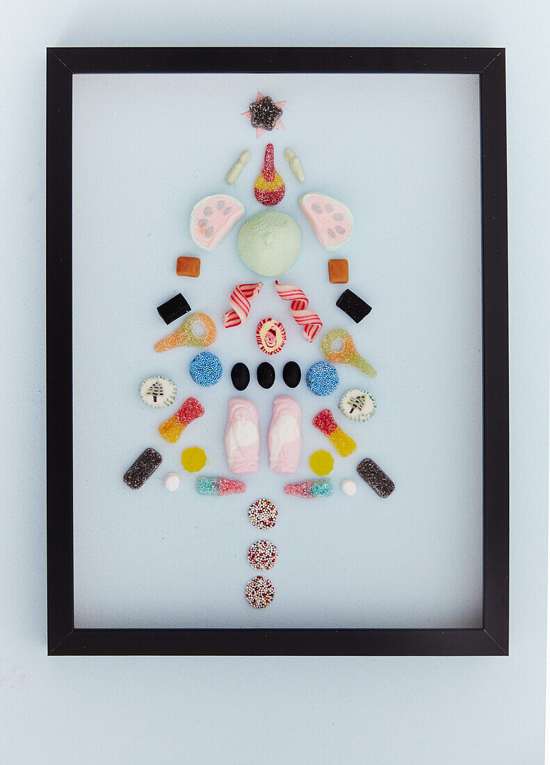 Stylized Christmas tree made of sweets in a black frame