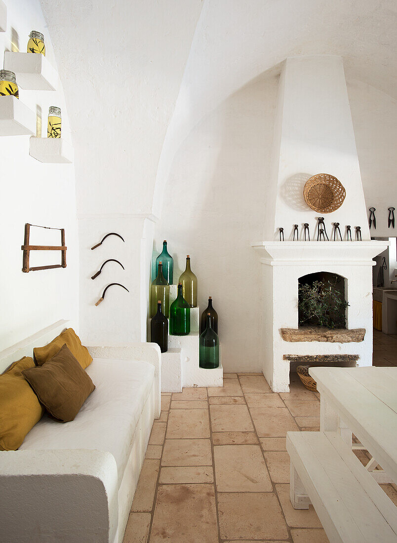 Mediterrane Küche mit Sitzbank, bunte Flaschen und gemauertem Kamin