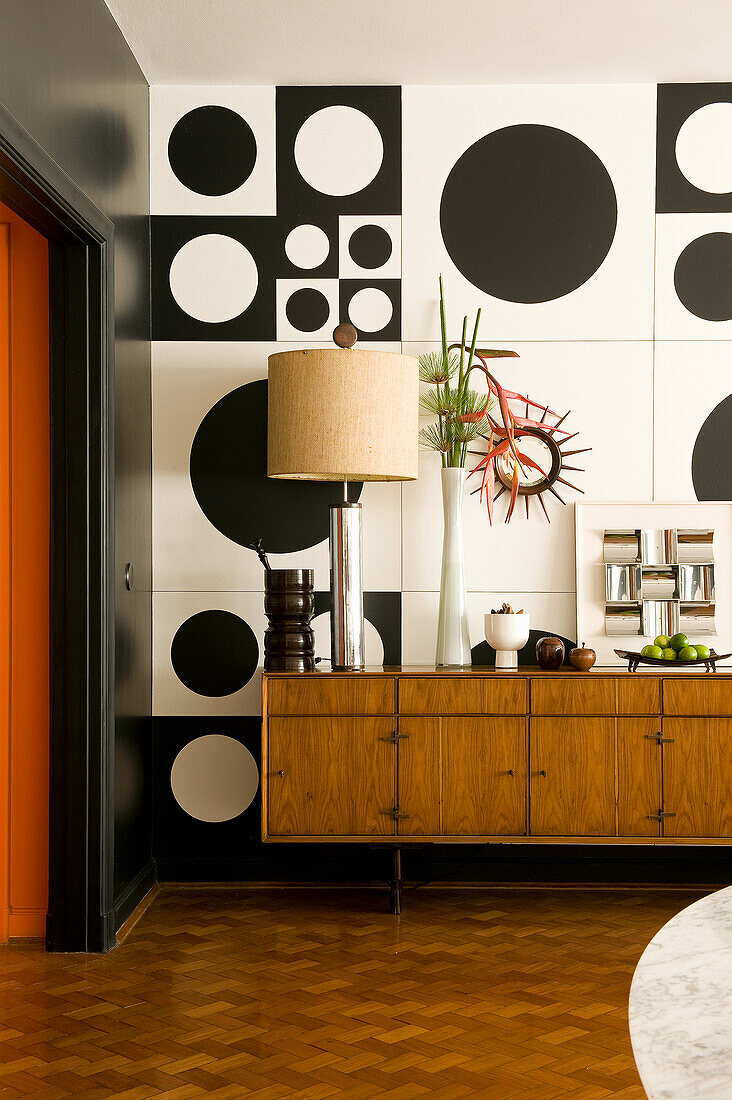 Sideboard in the living room in 60s style with black and white wall decoration