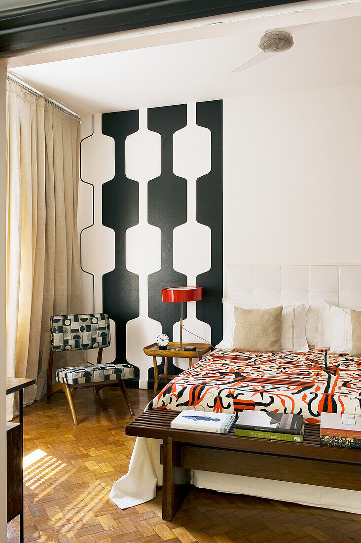 Bedroom in 60s style with double bed and black-and-white wall decoration