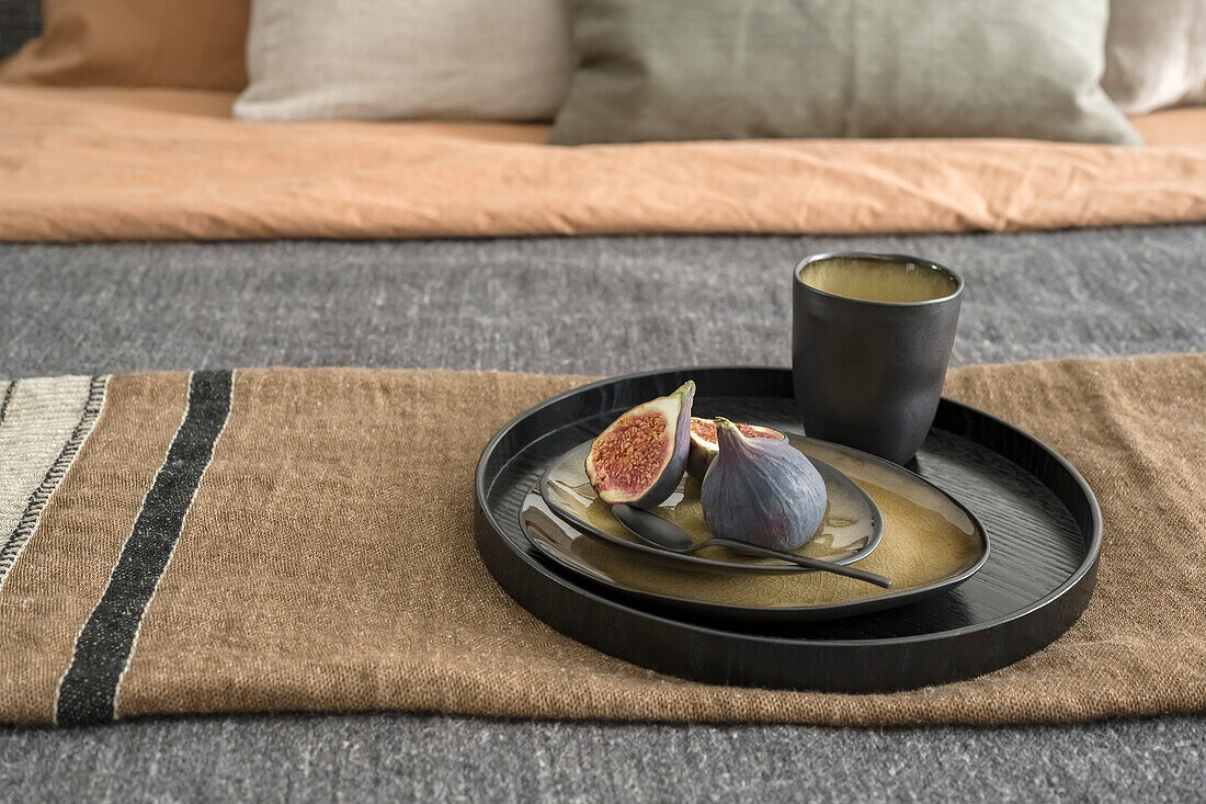 Tray with figs on bed with bedspread