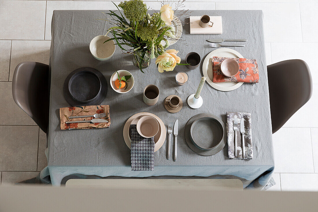 Gedeckter Tisch mit Leinendecke und Keramikgeschirr in Naturtönen