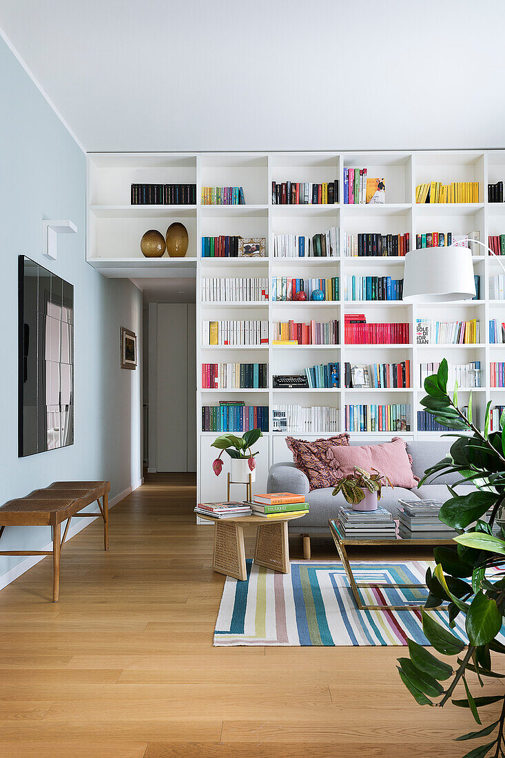 Floor-to-ceiling bookcase and sofa in living room