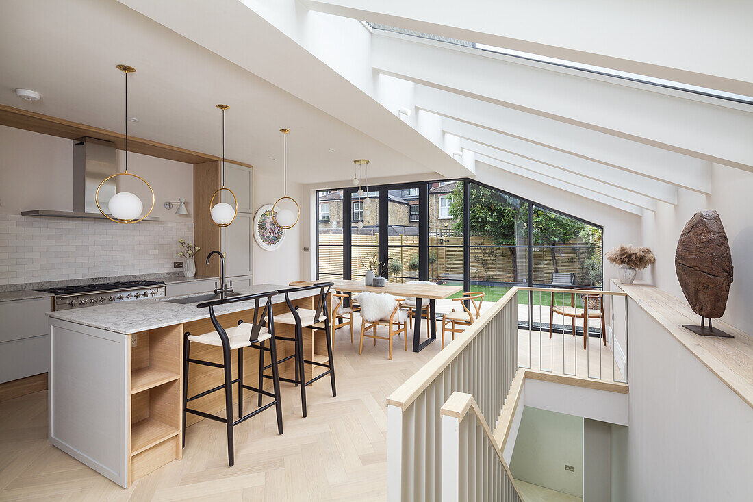 Kitchen with island counter and dining area in open-plan interior with skylights