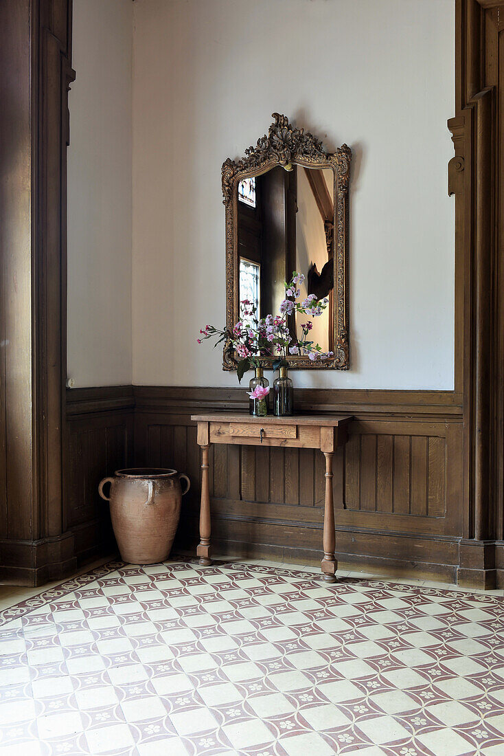 Console table and wall mirror in a tiled floor entrance hall