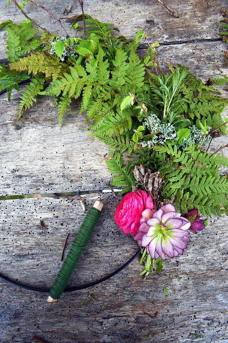 Spring wreath made of ferns, ranunculus and double hellebore