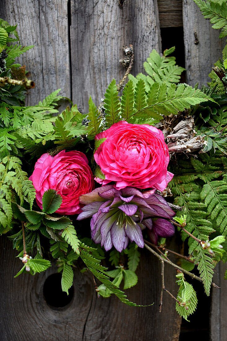 Wreath of ferns with ranunculus and double hellebore flowers