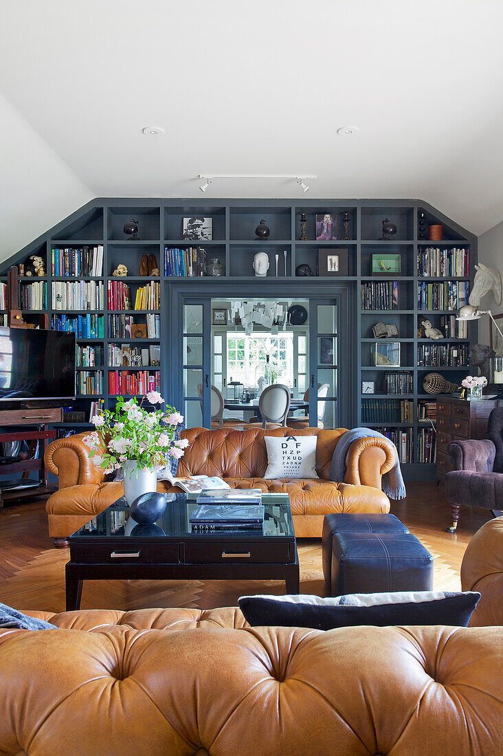 Cognac colored leather sofas, coffee table and floor-to-ceiling built-in bookcase in the living room