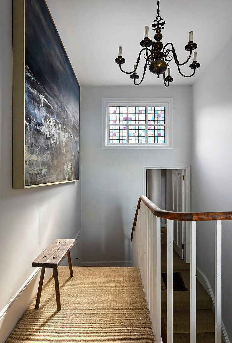 Treppenabsatz mit Buntglasfenster, dramatisches Kunstwerk unter rustikaler Eichenbank