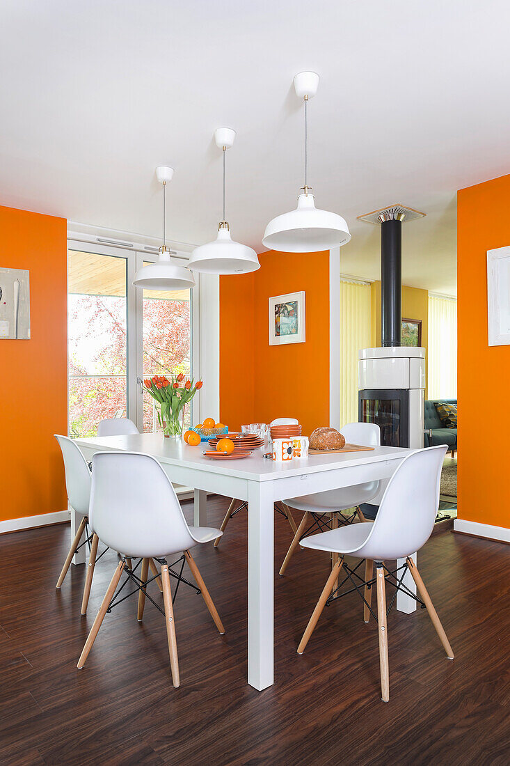 White table and chairs in dining area with orange walls