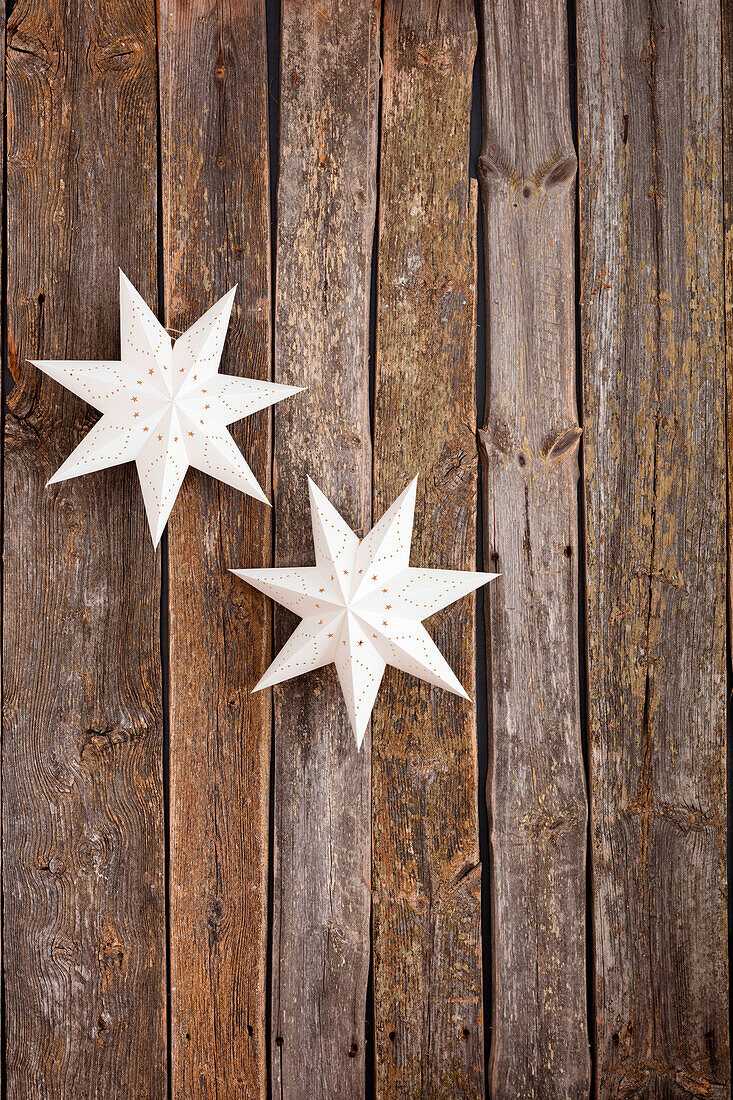 Paper stars on a rustic wooden wall as Christmas decorations