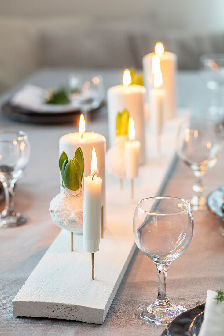 Gedeckter Esstisch mit weißem Brett, Kerzen und Hyazinthen