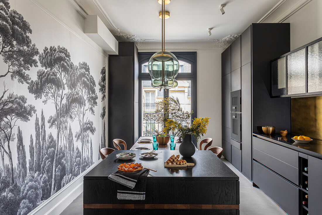 Modern kitchen with monochrome landscape wallpaper and central dining table