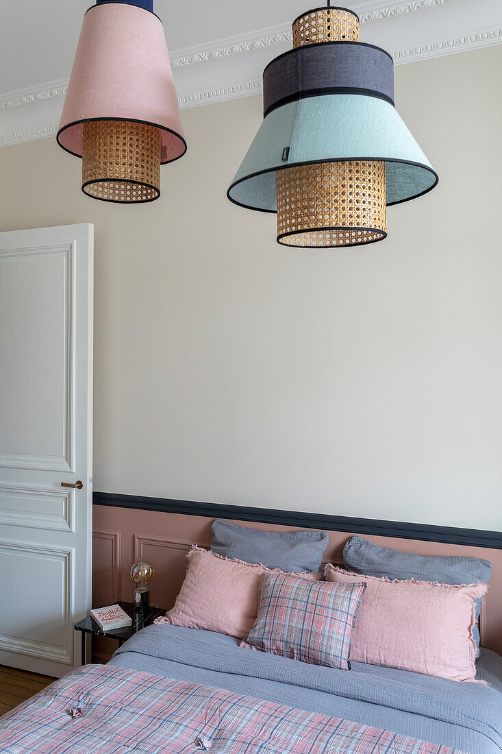 Pendant lights above bed with bed linen in pink and blue