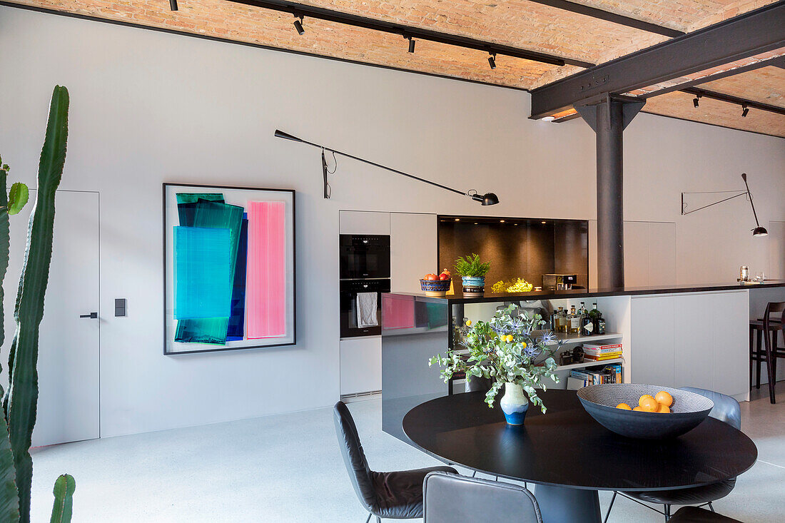 Loft kitchen with dining area, modern art on the wall and beams