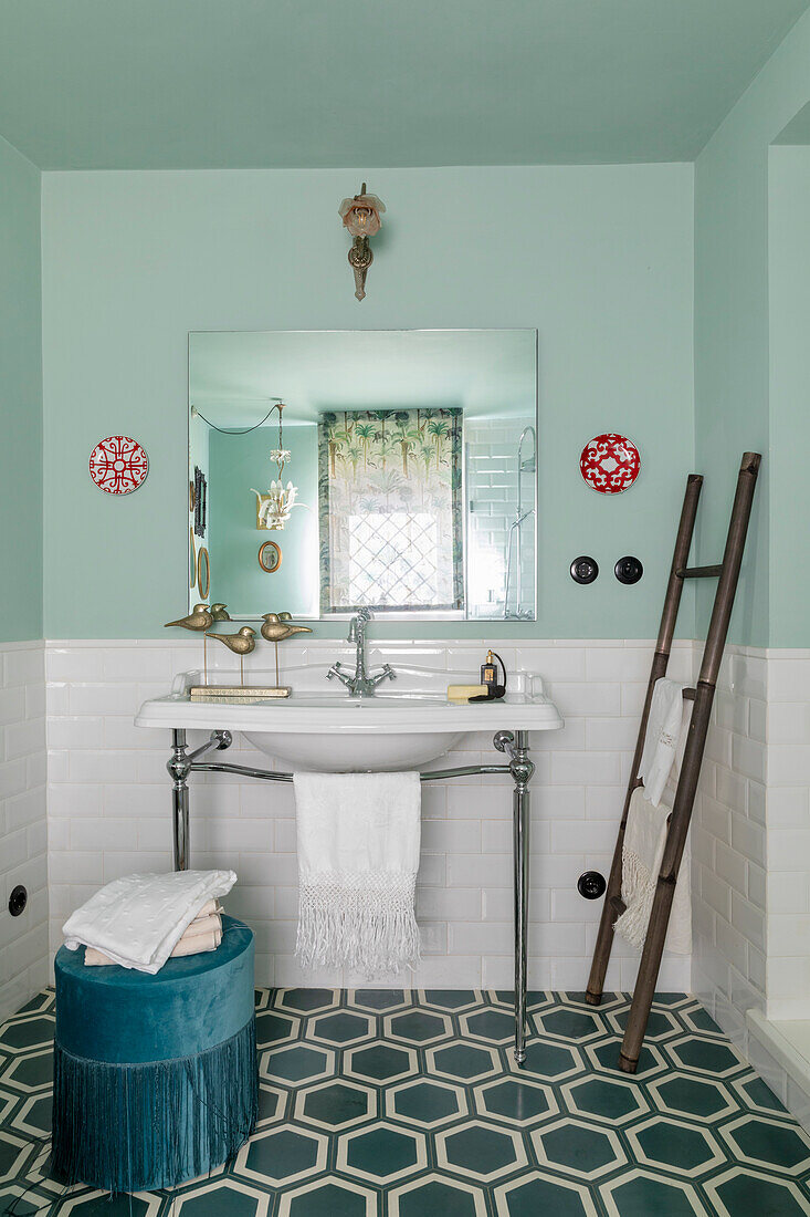 Bathroom with pastel green walls, patterned floor tiles and ladder