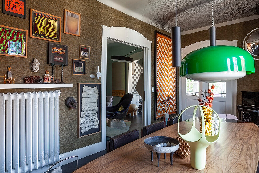 Dining table, colourful wall art and green hanging lamp