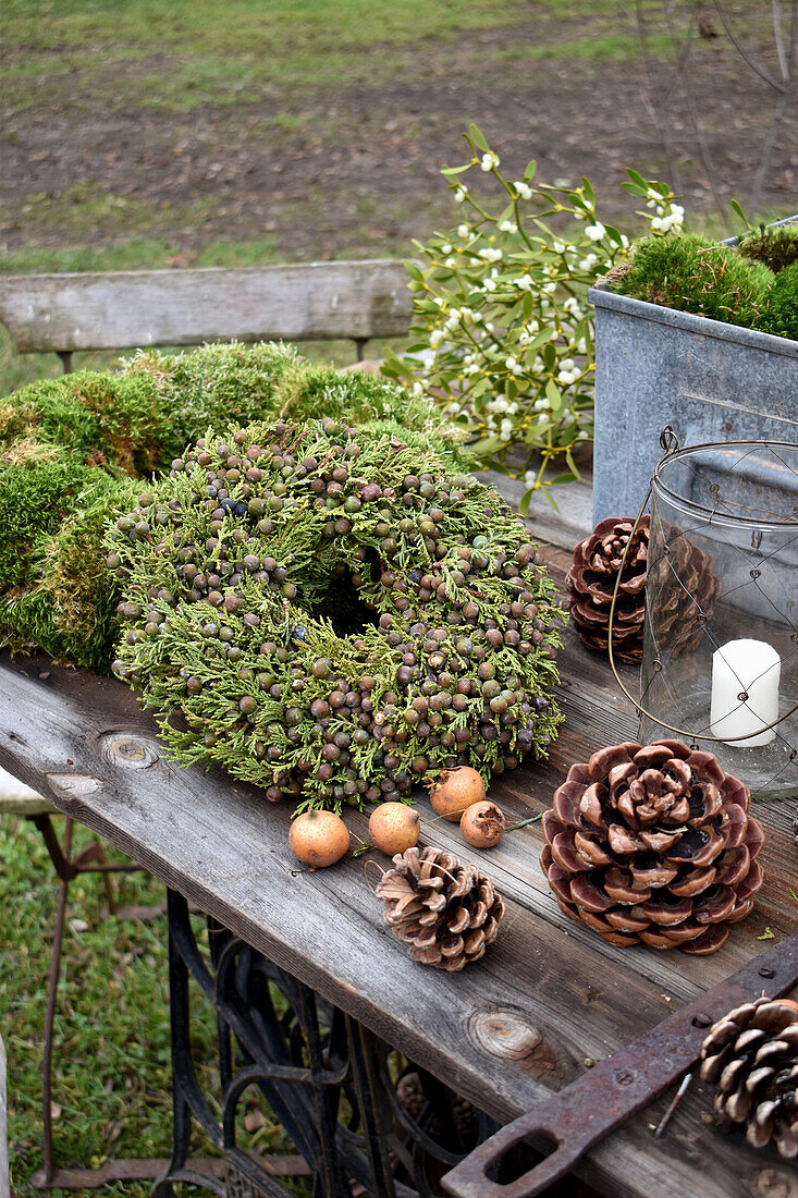Juniper wreath and cones on table in garden