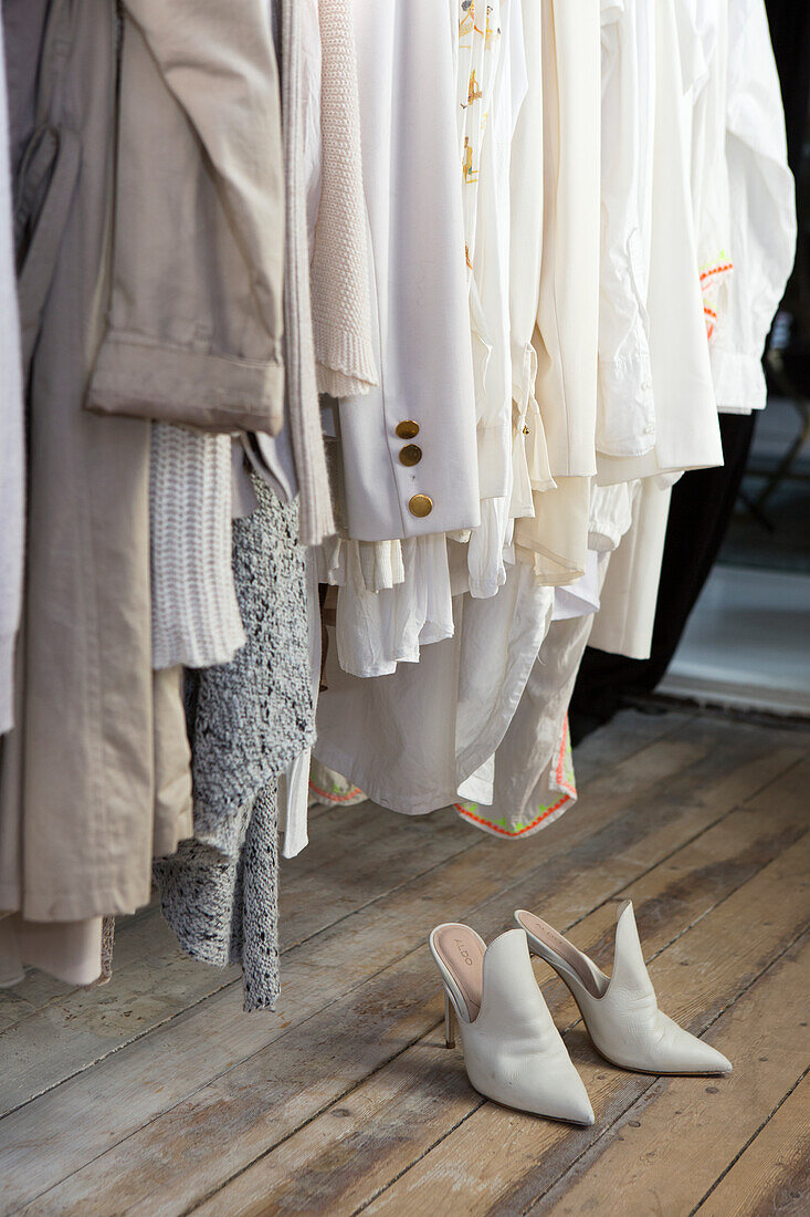 Light-coloured clothes and white shoes on wooden floor