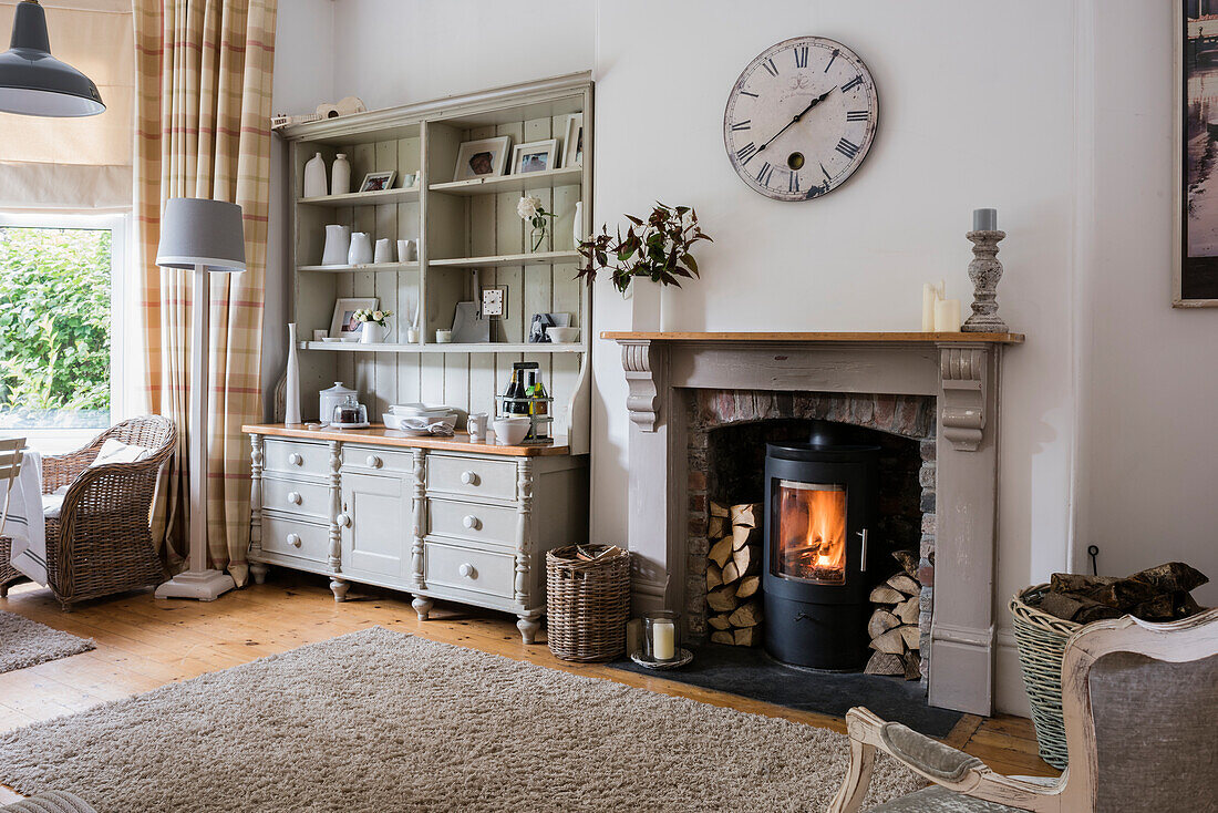 Wohnzimmer mit Kamin und weißem Regalschrank im Landhausstil