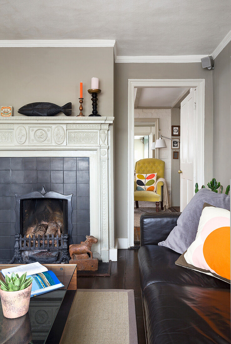 Living room with black fireplace and black leather sofa