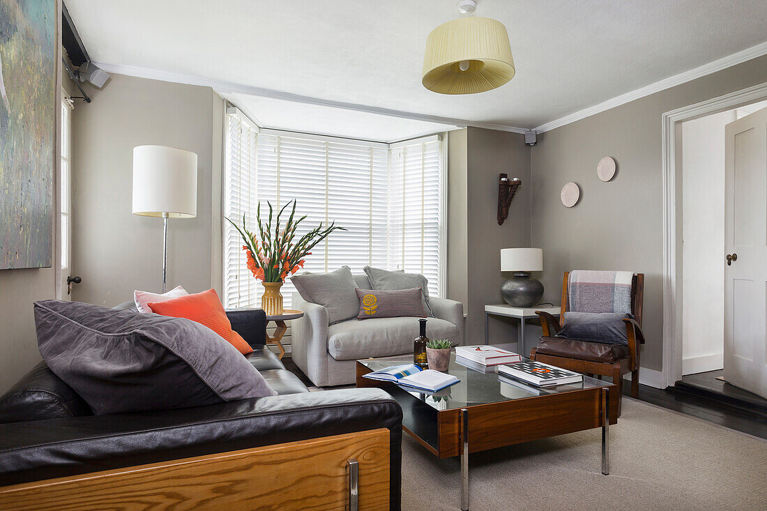 Modern living room with black leather sofa and wooden furniture