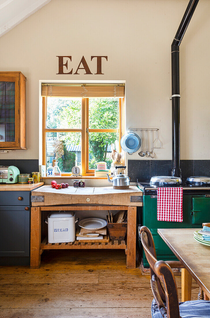 Country-style kitchen with wooden counter and EAT lettering above the window