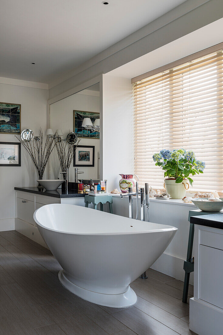 Freestanding bathtub in modern bathroom with wooden blinds