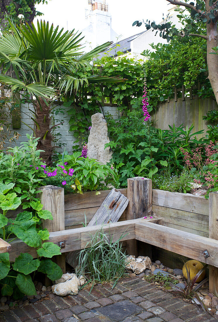 Wildly planted beds made of wooden planks in a courtyard garden