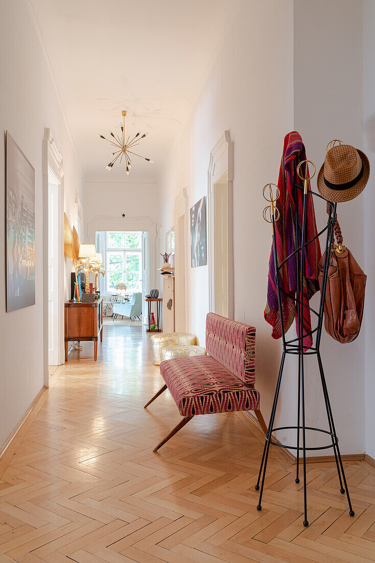 Bright vintage-style hallway with patterned bench and coat rack